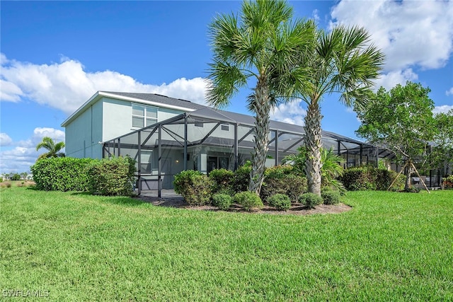 back of house with a lanai and a yard