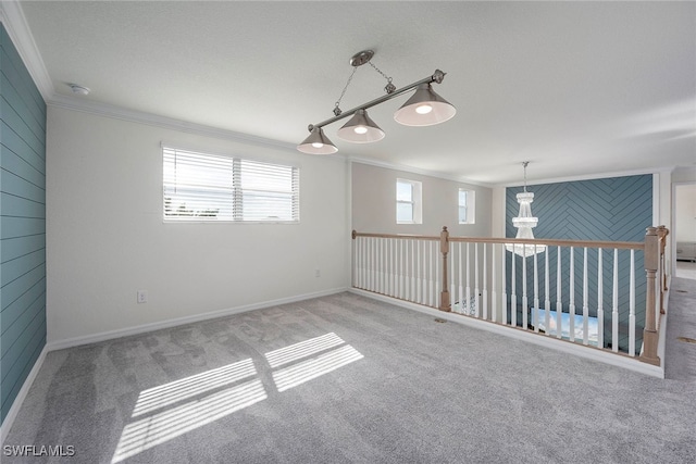 carpeted spare room featuring crown molding and wooden walls