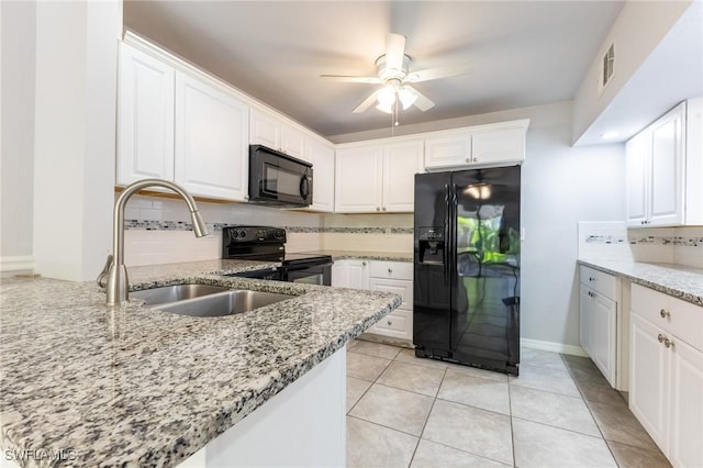 kitchen featuring white cabinets, light stone countertops, and black appliances