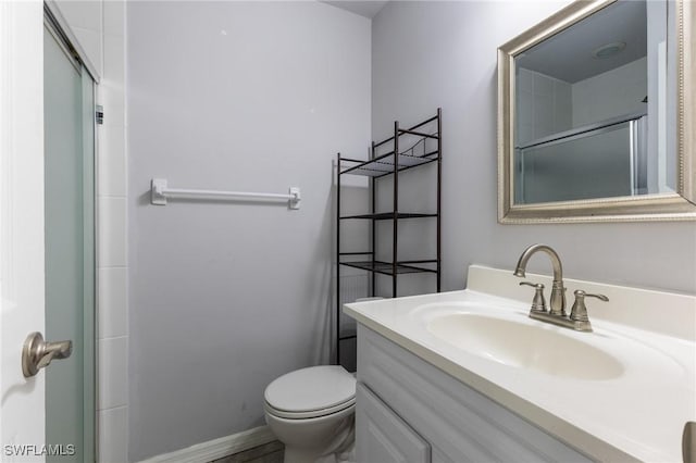 bathroom with vanity, toilet, and a shower with shower door