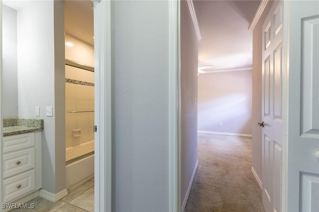 corridor with crown molding and light colored carpet