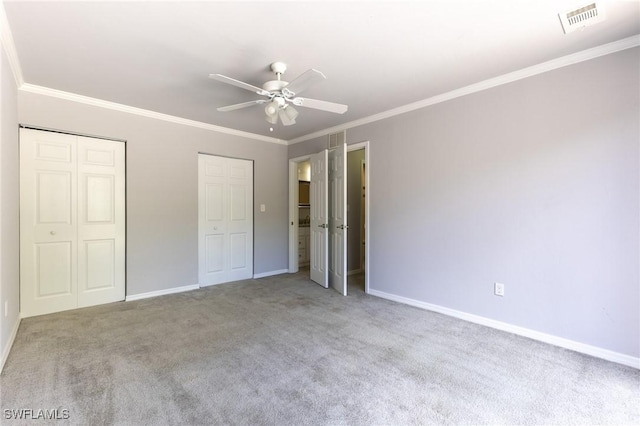 unfurnished bedroom featuring ceiling fan, light colored carpet, and two closets