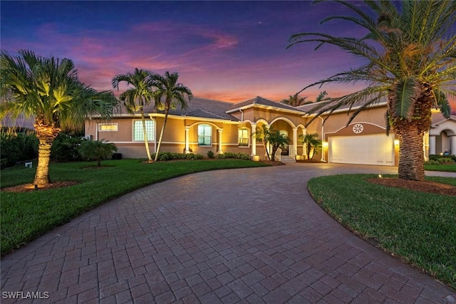 mediterranean / spanish-style home with a yard and a garage