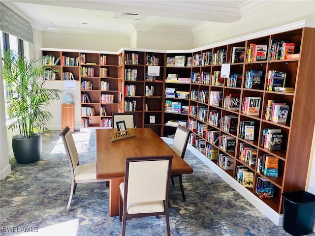 home office with crown molding, bookshelves, and visible vents