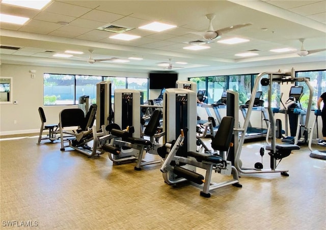 gym featuring baseboards, visible vents, a drop ceiling, and ceiling fan