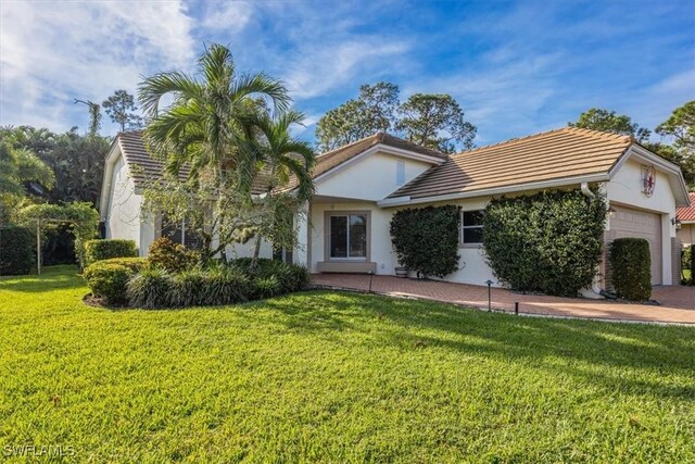 view of front of home with a garage and a front lawn