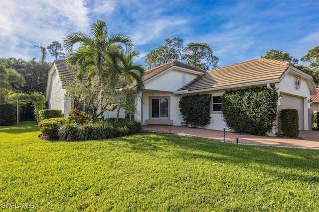 view of front of home featuring stucco siding, an attached garage, and a front yard