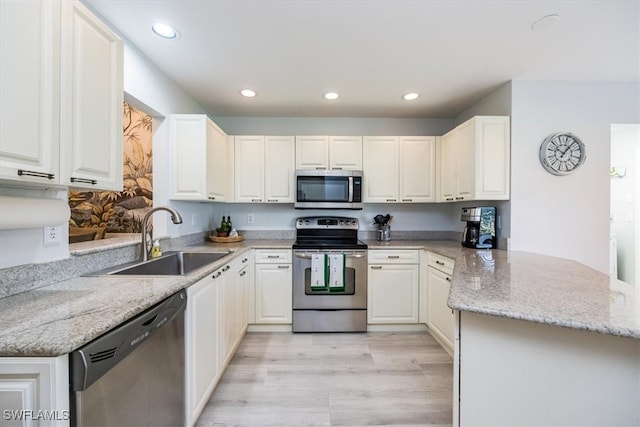 kitchen featuring a sink, stainless steel appliances, a peninsula, and recessed lighting