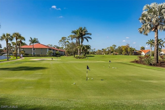 surrounding community featuring a lawn and golf course view