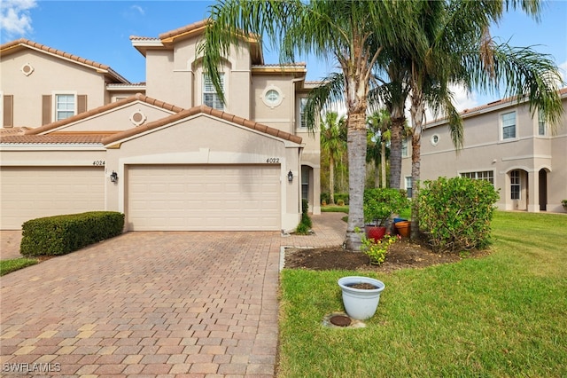 mediterranean / spanish-style house featuring a front yard and a garage