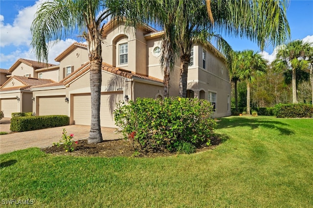 mediterranean / spanish-style home with a garage and a front lawn