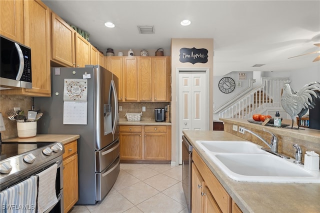 kitchen featuring light brown cabinetry, tasteful backsplash, stainless steel appliances, sink, and light tile patterned floors