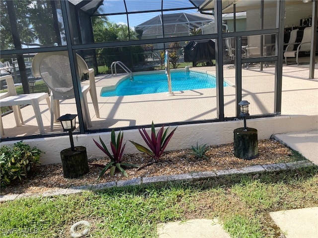 view of pool featuring a patio area and glass enclosure