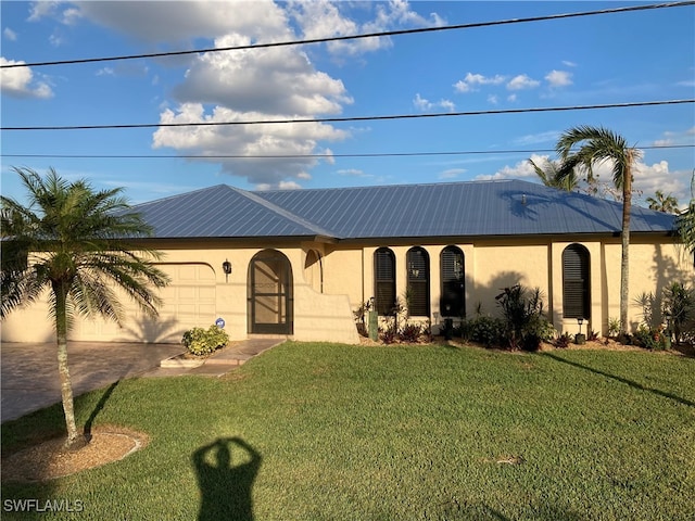 view of front of property with a front yard and a garage