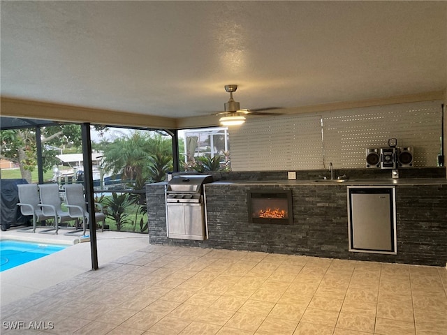 kitchen featuring stainless steel fridge, ceiling fan, plenty of natural light, and sink