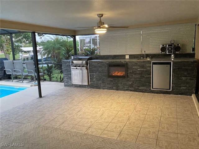 view of patio / terrace featuring ceiling fan, sink, exterior kitchen, a lanai, and a grill