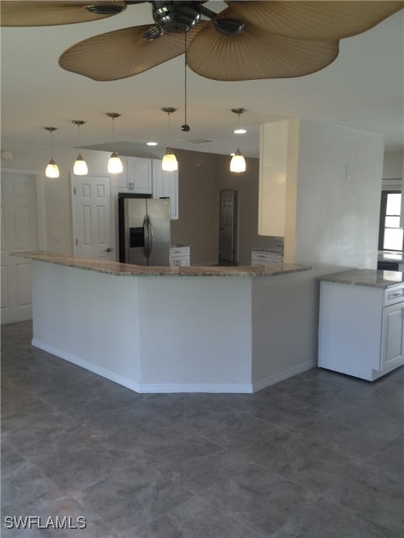 kitchen with kitchen peninsula, stainless steel fridge with ice dispenser, white cabinets, and decorative light fixtures