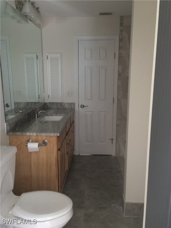 full bathroom with tile patterned floors, washtub / shower combination, vanity, and toilet