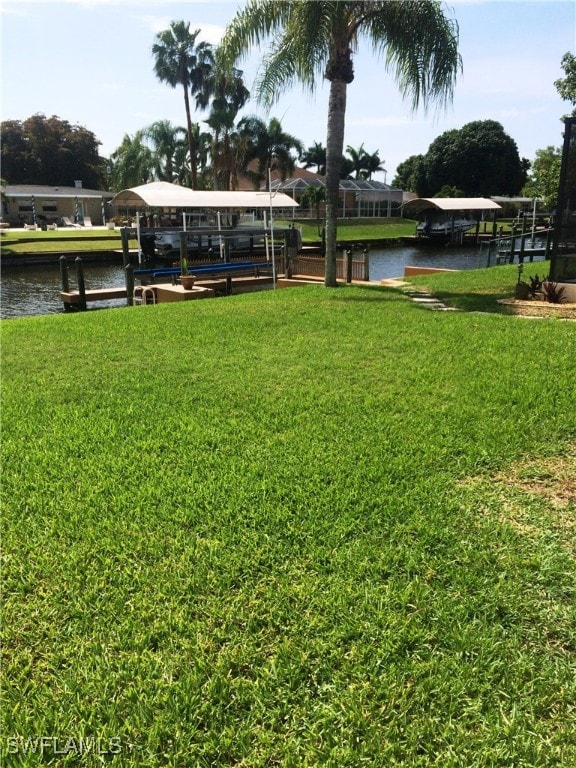 view of yard featuring a boat dock and a water view