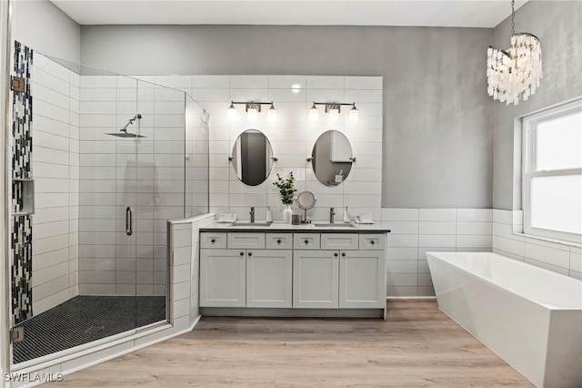 bathroom featuring vanity, separate shower and tub, hardwood / wood-style floors, and tile walls