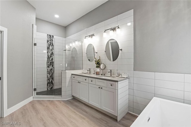 bathroom featuring vanity, shower with separate bathtub, hardwood / wood-style floors, and tile walls