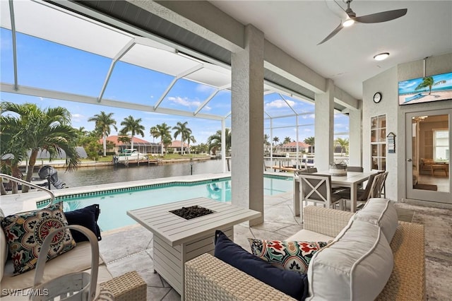 view of swimming pool featuring ceiling fan, outdoor lounge area, glass enclosure, and a patio area