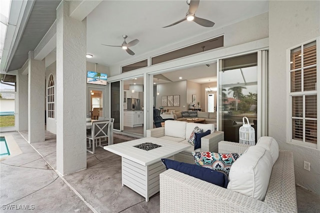 view of patio / terrace with ceiling fan and an outdoor living space with a fire pit