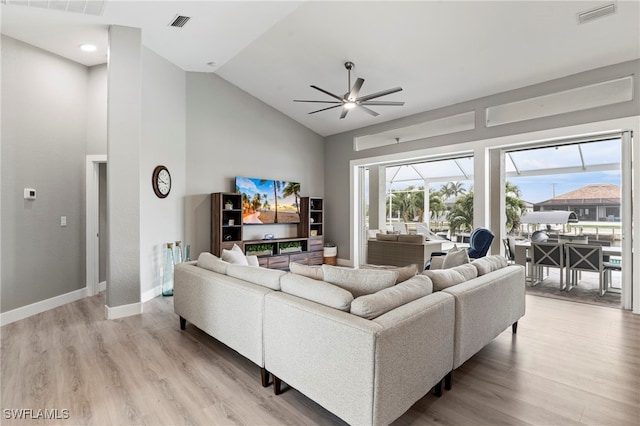 living room with ceiling fan, lofted ceiling, and light hardwood / wood-style flooring