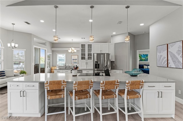 kitchen featuring stainless steel fridge with ice dispenser, plenty of natural light, and a large island