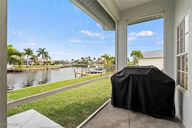 view of patio with grilling area and a water view