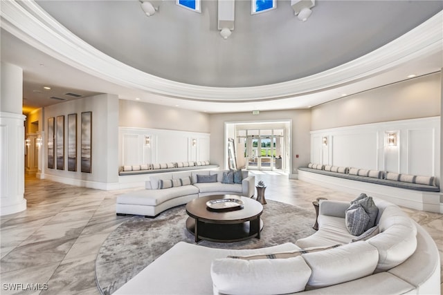 living room with ornate columns and a raised ceiling