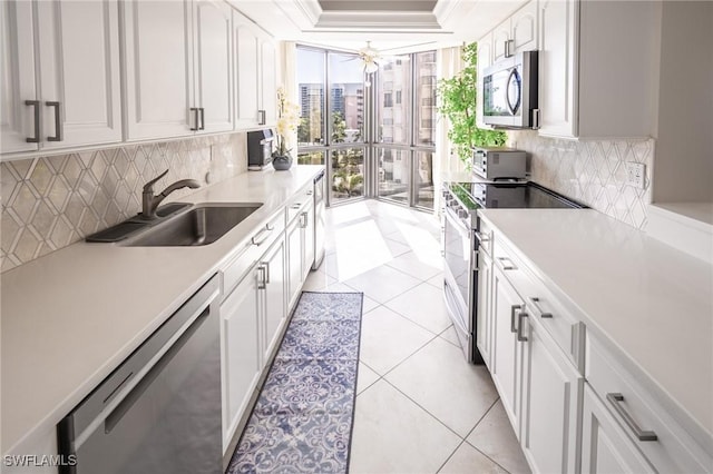 kitchen featuring sink, white cabinetry, stainless steel appliances, and light tile patterned floors