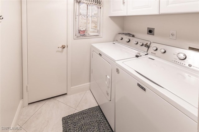 laundry area with light tile patterned flooring, cabinets, and independent washer and dryer