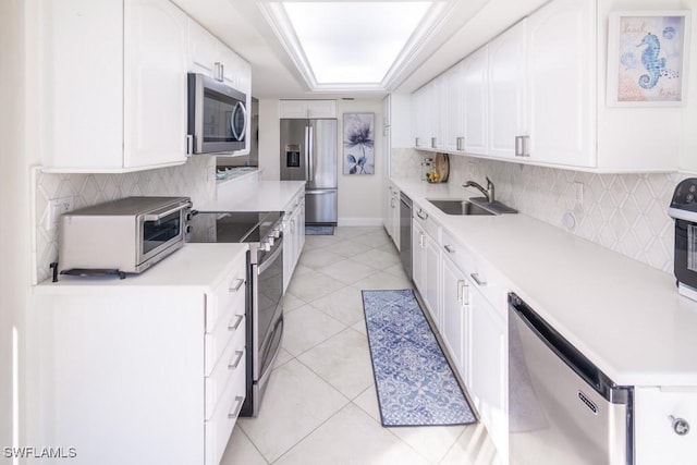 kitchen featuring sink, light tile patterned flooring, backsplash, white cabinets, and appliances with stainless steel finishes