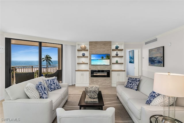 living area featuring built in features, visible vents, crown molding, and a tiled fireplace