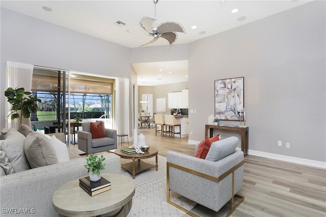 living room with ceiling fan and light hardwood / wood-style flooring