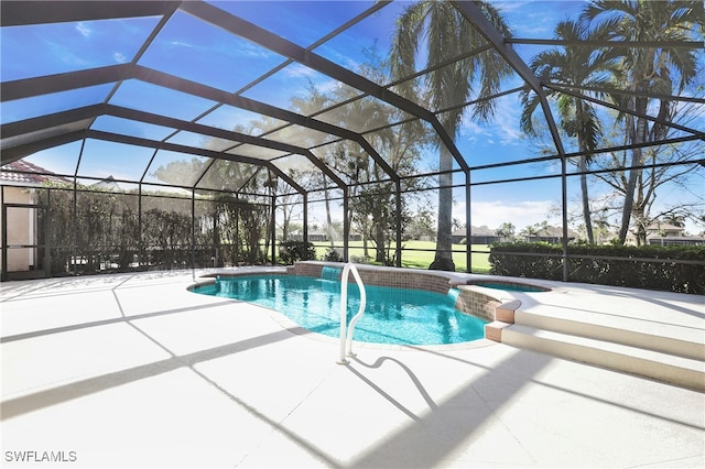 view of pool featuring glass enclosure, an in ground hot tub, and a patio area