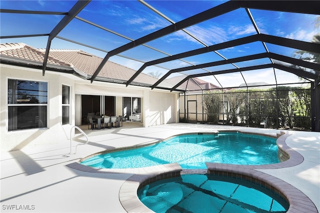 view of pool with an in ground hot tub, a patio, and a lanai