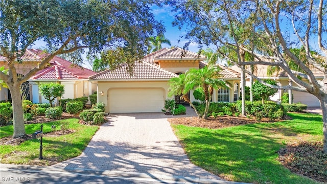 mediterranean / spanish-style house with a garage and a front lawn