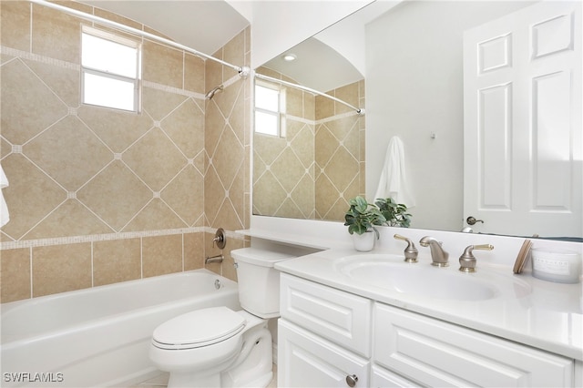 full bathroom with tiled shower / bath, vanity, toilet, and a wealth of natural light