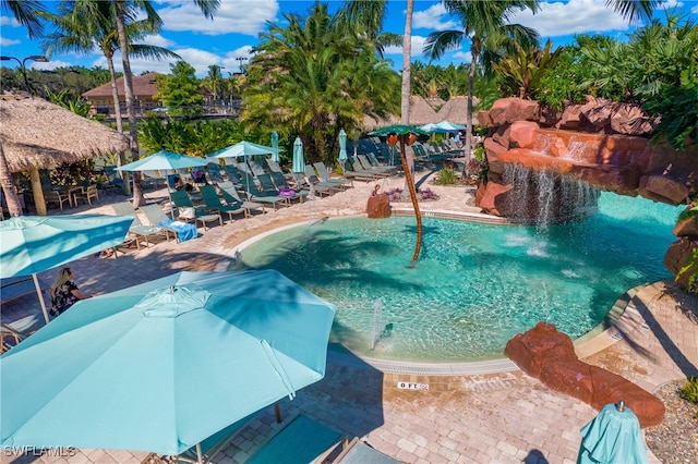 view of swimming pool with pool water feature and a patio