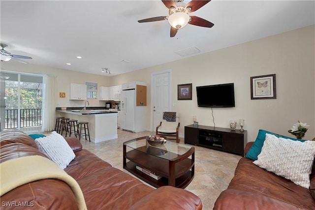 living room featuring ceiling fan and sink