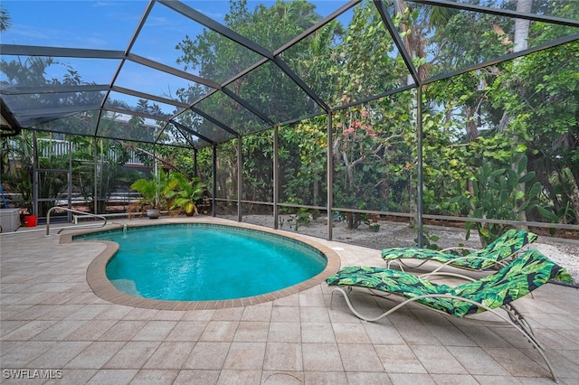 view of swimming pool featuring a lanai and a patio