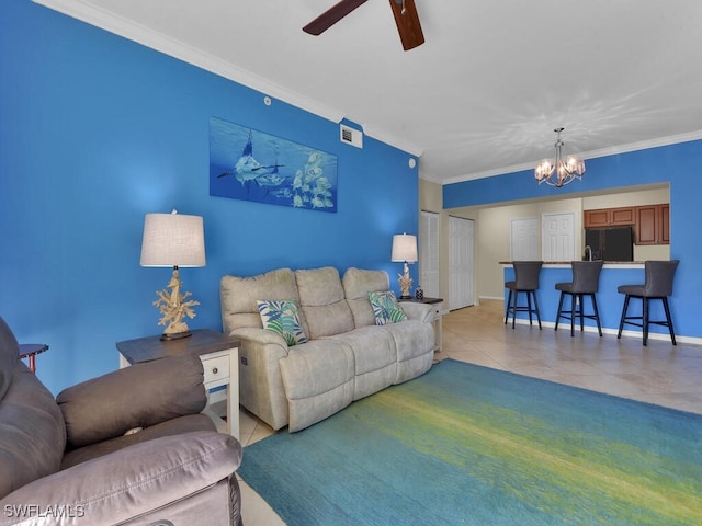 tiled living room with ceiling fan with notable chandelier and crown molding