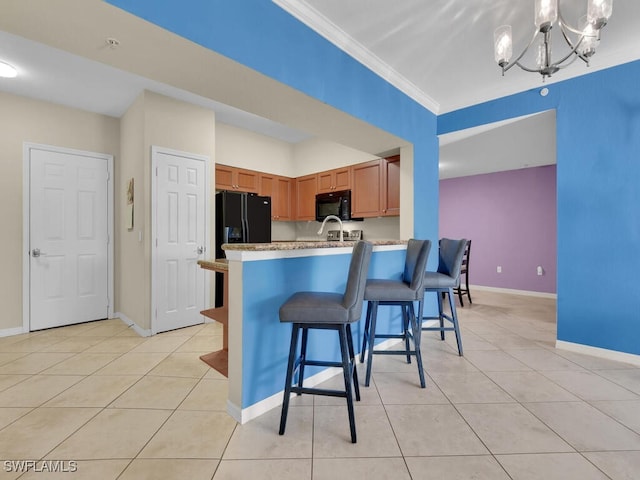 kitchen featuring a breakfast bar, black appliances, ornamental molding, light tile patterned flooring, and kitchen peninsula