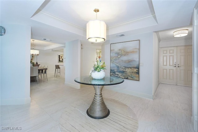 hall featuring a tray ceiling and crown molding