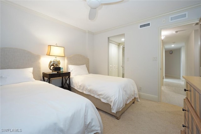 bedroom featuring ornamental molding, a closet, ceiling fan, and light colored carpet