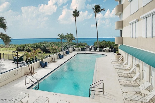 view of swimming pool featuring a patio area and a water view