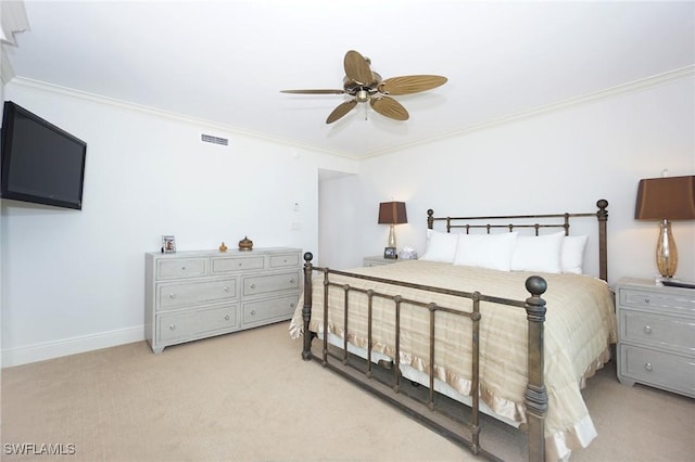 carpeted bedroom featuring ceiling fan and crown molding