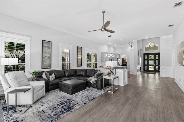 living room with crown molding, dark wood-type flooring, ceiling fan, and french doors